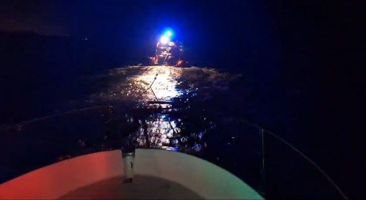 Intervention de nuit, gyrophare bleu allumé sur l'eau